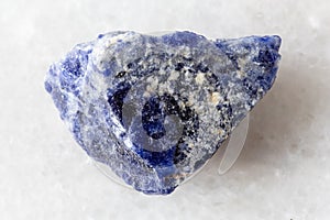 sample of raw sodalite rock on white marble