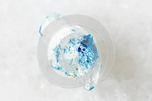 sample of rough euclase crystal on white marble