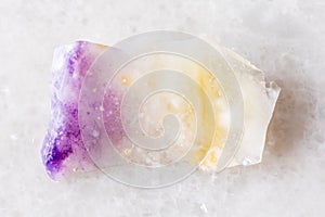 sample of rough opal mineral on white marble