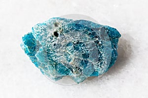 sample of uncut apatite rock on white marble