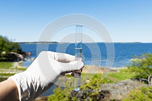 Sample water from the sea for analysis. Sea on background photo