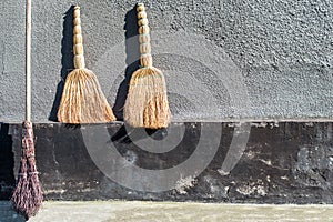 The sampler brooms for cleaning and the factory two brooms against the wall