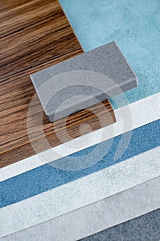 samples of finishing materials, close-up view, including various wooden laminates, interior wallpaper, gray artificial stone