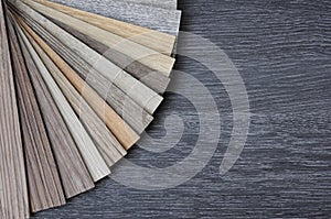 Samples of laminate and vinyl floor tile on black wooden Background photo