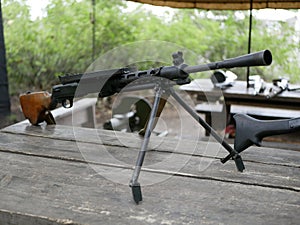 Samples of Soviet automatic weapons of the second world war. Machine guns and machine guns on a wooden table outside on a summer d
