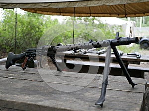 Samples of Soviet automatic weapons of the second world war. Machine guns and machine guns on a wooden table outside on a summer d