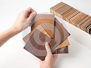 Samples of veneer wood on white background. interior design select material for idea.Hand holding veneer wood.
