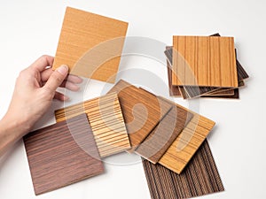 Samples of veneer wood on white background. interior design select material for idea.Hand holding veneer wood.