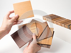 Samples of veneer wood on white background. interior design select material for idea.Hand holding veneer wood.