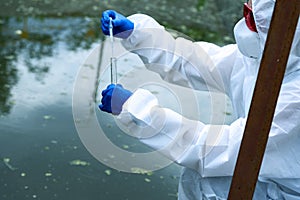 Sampling from open water. A scientist or biologist takes a water sample. Water sample in a chemical test tube with a
