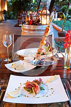 Luxury resort restaurant dinner table setting with barbecue and