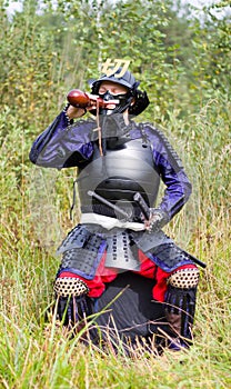 Samurai in armor drinking from flask