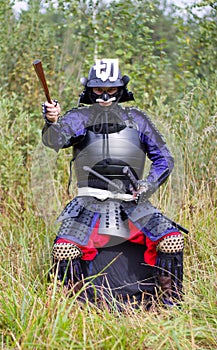 Samurai in armor showing direction by folded fan