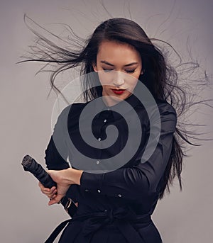 Samurai, ninja and woman with sword in studio  on a gray background. Face, sports and martial arts meditation of