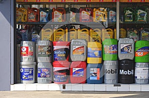 Rows of various different types of motor oil canisters display for sale in front of car spare parts shop