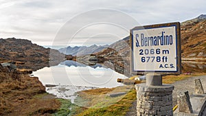 San Bernardino mountain pass, Switzerland. The sign with the altitude of the pass and the lake Moesola in the background