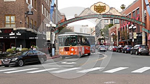 SAN DIEGO, CALIFORNIA USA - 30 JAN 2020: Gaslamp Quarter historic entrance arch sign on 5th avenue. Orange iconic retro trolley,