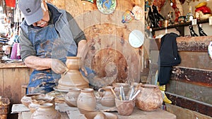 SAN DIEGO, CALIFORNIA USA - 5 JAN 2020: Potter working in mexican Oldtown, raw clay on pottery wheel. Man`s hands, ceramist in