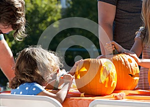Kids carving pumpkins at Senator Scott Wieners Halloween Pumpkin Carving Event