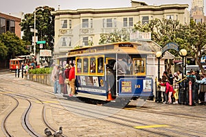 San Francisco, California / United States of America - May 27th 2013: People traveling on the historic yellow and blue cable car