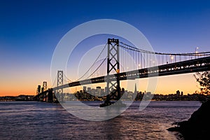 San Francisco skyline and Bay Bridge at sunset, California