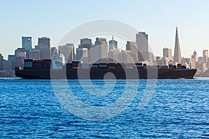 San francisco Skyline with merchant ship cruising bay at California