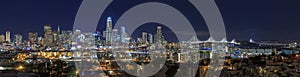 San Francisco skyline night panorama with city lights, the Bay Bridge and light trails on the highway