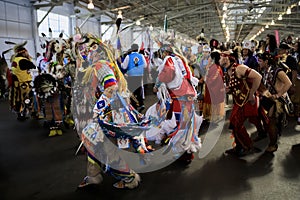 Native American Indians dressed in intricate and colorful traditional outfits dancing at a powwow in San Francisco, USA