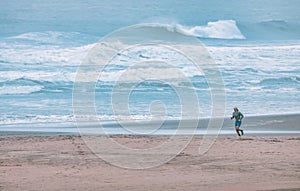 San Francisco, USA - October 23, 2021, a lone runner runs on the beach on a cold foggy day in San Francisco. Concept, morning