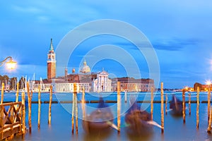 San Giorgio Maggiore church and gondolas in Venice, Italy during blue hour sunrise. Focus on the church.