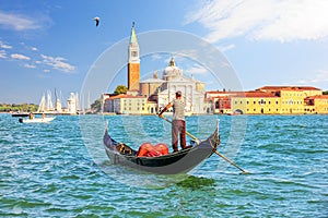 San Giorgio Maggiore Island of Venice and a traditional gondolier in his gondola photo