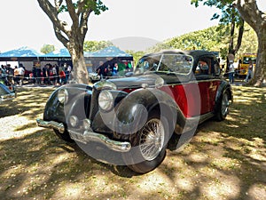 Old black and red 1943 Riley RMB 2.5 in a park. Nature, trees. Autoclasica 2022 classic car show