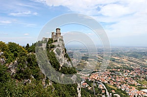 San marino. Emilia-Romagna. Castle on the rock and view of town on blue sky background, horizontal view.