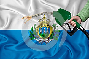 SAN MARINO flag Close-up shot on waving background texture with Fuel pump nozzle in hand. The concept of design solutions. 3d