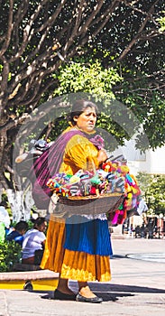 Mexican woman with traditional dress selling handcrafts