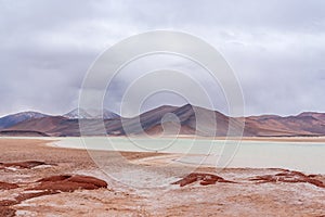 Frozen lagoon and snowy mountains in Atacama desert