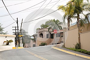 San Pedro Garza Garcia, Mexico Ã¢â¬â March 20, 2023: View of city street with road, beautiful houses and green palms photo