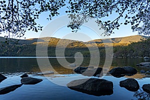 Sanabria Lake Natural Park in autumn at sunset with the mountains reflected in the water, Zamora, Castilla y LeÃ³n, Spain