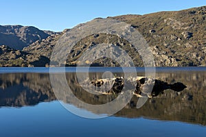 Sanabria Lake Natural Park in autumn at sunset with the mountains reflected in the water, Zamora, Castilla y LeÃ³n, Spain