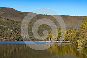 Sanabria Lake Natural Park in autumn at sunset with the mountains reflected in the water, Zamora, Castilla y LeÃ³n, Spain