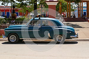 SANCTI SPIRITUS, CUBA - Apr 24, 2018: Classic Blue Car Parked on a Principal Square in a Sunny Day