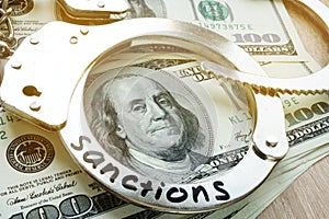 Sanctions on a handcuffs and American dollar bills. Economical restrictive measures.