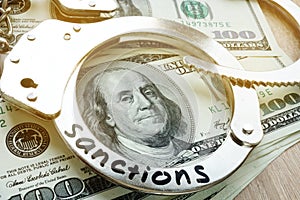 Sanctions on a handcuffs and American dollar bills. Economical restrictive measures. photo