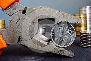Sanctions for Russia and inflation. Pliers holding russian ruble. photo