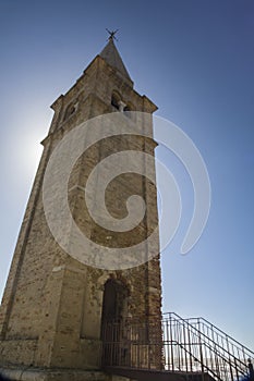 Sanctuary Madonna dell`Angelo bell tower in Caorle during sunset with the sea and blue sky in the background