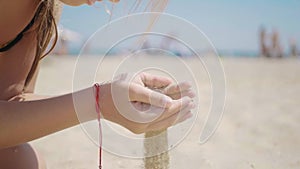 Sand as the time slips through your fingers. Little girl holding a sand sea background. Sand in your hands. Concept of