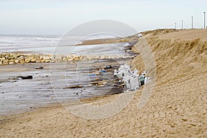 Sand bags in sandy beach try to stop erosion sea ocean