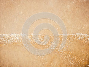 Sand beach background, natural sea texture with little foam. Aerial top view