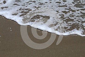 Sand on the beach and bubbling waves