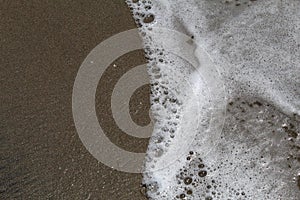 Sand on the beach and bubbling waves